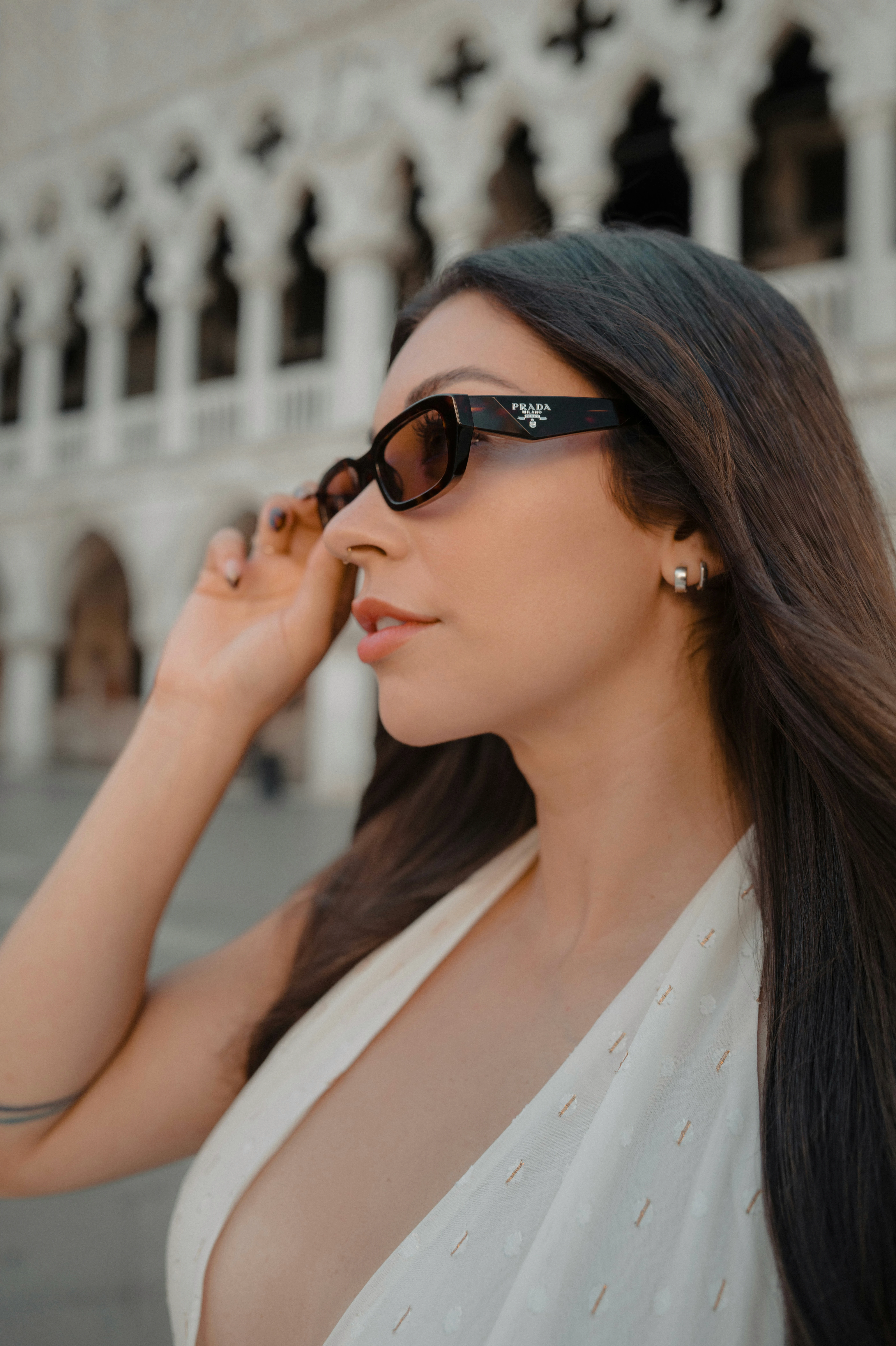Woman wearing sunglasses with ornate building background